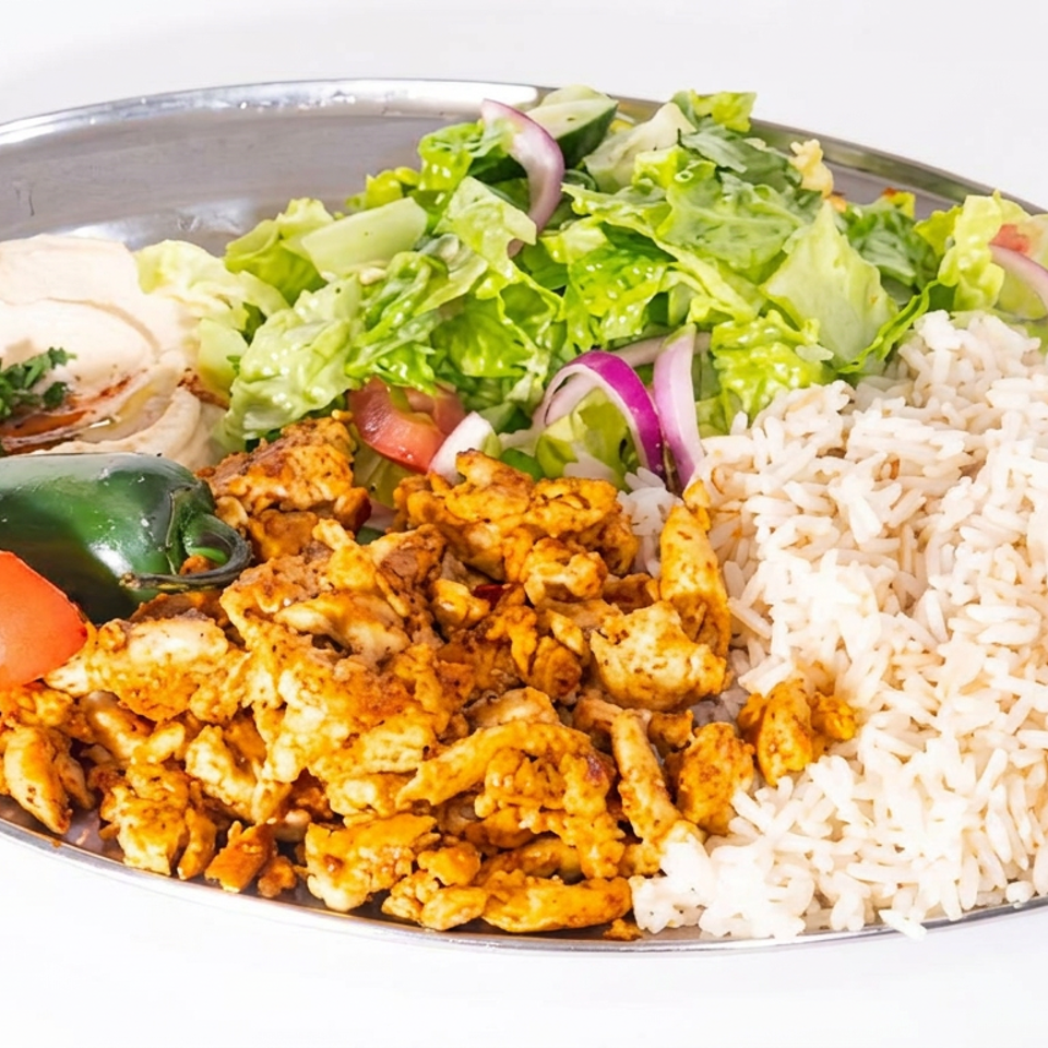 Plate of seasoned grilled chicken with white rice, green salad, hummus, pita, tomato, and pepper.